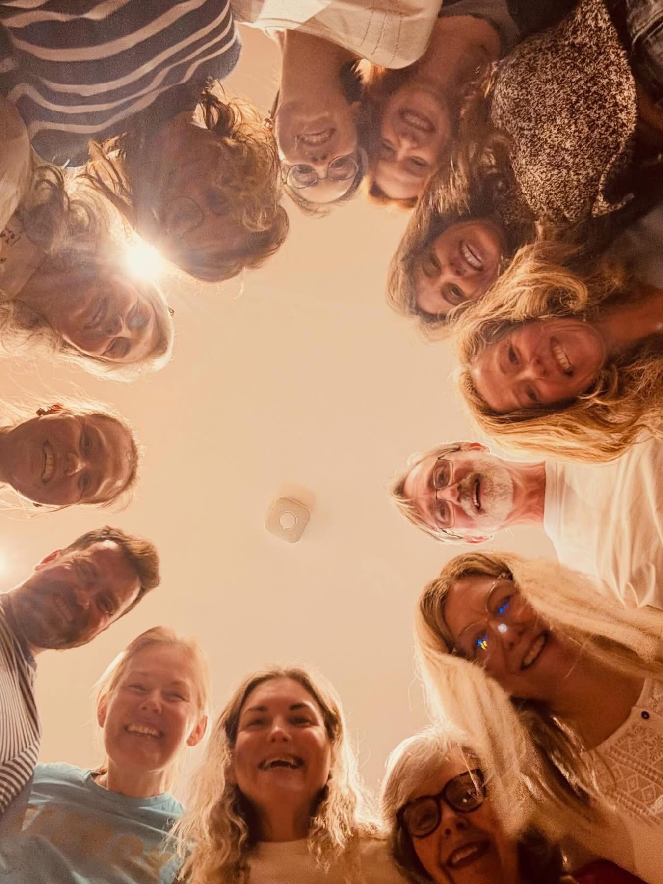 Cadence members smiling together in a circle, photographed from below